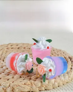 Close-up of mini resin ice cream bucket keychains with cream flower on straw mat