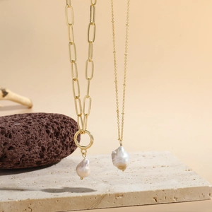 Detail of baroque freshwater pearl pendants on gold paperclip and beaded chain necklaces