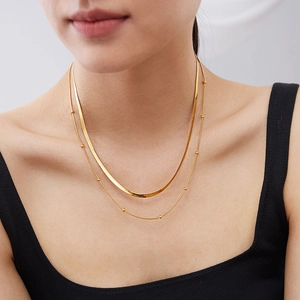 Dubbellaagse gouden titanium stalen platte slangenketting set gedragen door een model