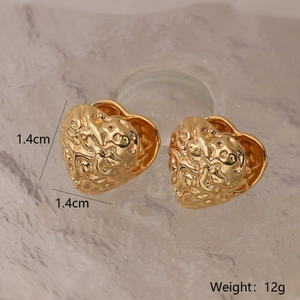 Dettaglio orecchini a cuore in oro testurizzato da 1,4 cm, peso 12g su sfondo marmo