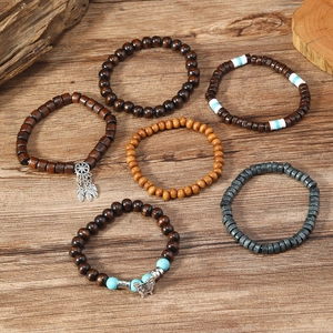 Detail of 6-piece handmade wooden bead bracelets with turquoise and feather charms