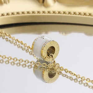 Macro shot of gold cylinder pendant with white inlay and sparkling crystal border