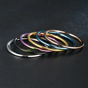 Vista detallada de anillos apilables de metal ultrafino en varios colores pulidos.