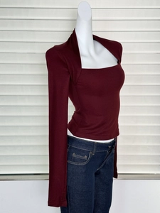 Détail du haut en tricot bordeaux avec une coupe ajustée et encolure carrée