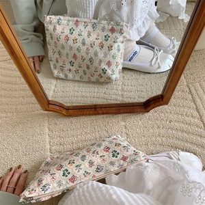 Mirror selfie showing the floral cotton makeup bag in use with soft natural lighting
