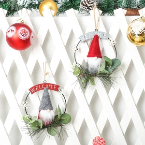 Detail view of festive Christmas gnome iron wreaths hanging on a white lattice background