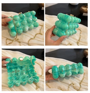 Détails de la pochette en acrylique marbré vert avec chaîne et fermoir dorés