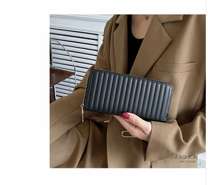 Fashionable black pleated PU leather long wallet held by a model in a professional blazer