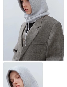 Detail of grey knitted balaclava texture and drawstring hood on a herringbone blazer