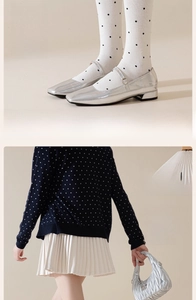 Detail of white polka dot socks with lace trim paired with silver Mary Jane shoes