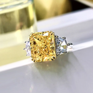 Macro shot of cushion-cut yellow gemstone ring with white shield side stones