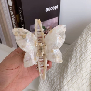 Detailed view of butterfly-shaped acetate hair claw clip with pearly marble texture