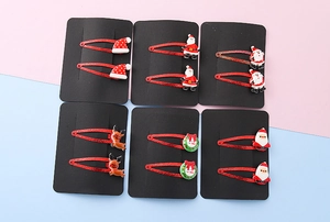 Detailed view of 12pcs Christmas hair clips with resin Santa and reindeer motifs