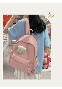 Pink minimalist backpack featuring a 3D floral charm and practical front zip pocket