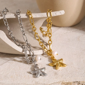 Detailed view of starfish pendants and pearls on gold and silver ocean charm bracelets