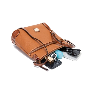 Internal view of brown pebbled leather crossbody bag showing spacious capacity and daily items