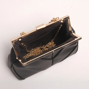 Quilted black clutch bag with gold frame and chain strap shown in an open view