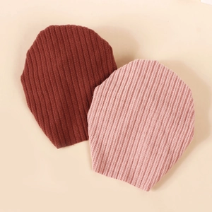 Baby-Strickmützen in Dunkelbraun und Hellrosa mit klassischem Rippenmuster für den Herbst