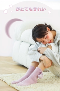 Detail of purple faux mink fur socks with pom-poms and ribbon bows for cozy winter wear