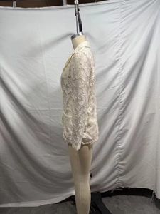Vue détaillée de la texture de dentelle florale sur le blazer ajusté blanc cassé
