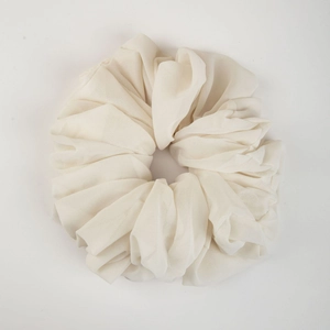 Close-up detail of white chiffon oversized hair scrunchie with soft fabric pleats