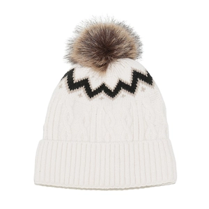 Detailaufnahme einer weißen Zopfstrickmütze mit schwarzem Zickzackmuster und Bommel