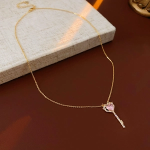 Detailed close-up of a golden S925 silver key necklace with a pink heart zircon stone