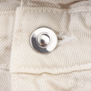Dettaglio degli shorts in denim crema a vita alta con bottone argento e doppia cucitura