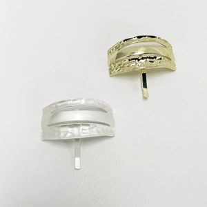 Detail of gold and silver U-shaped hair clips with textured hammered finish metal surface