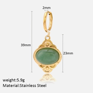 Macro detail of gold stainless steel hoop earrings with green tiger eye oval pendant