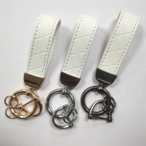 Three-piece set of white leather keychain straps with gold, silver, and gunmetal finishes
