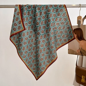 Detail of dark green paisley silk scarf with vintage pattern and red yellow borders