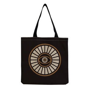 Detail of black canvas tote bag showing white stitching and mystical eye printed design