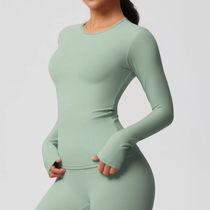 Détail du haut de yoga vert menthe à manches longues avec passe-pouces et coupe ajustée