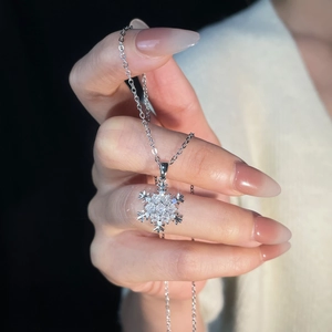 Detailed close-up of a silver snowflake pendant necklace with sparkling cubic zirconia