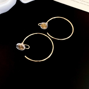 Vue détaillée de boucles d'oreilles clips dorées pour oreilles non percées sur fond noir