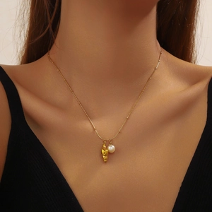 Gold-plated conch shell and pearl pendant necklace on model's neck for elegant look