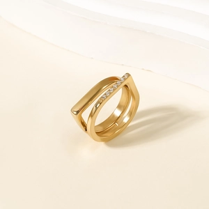 Detail eines goldfarbenen Doppelrings mit geometrischem Rahmen und Zirkonia-Besatz