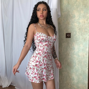 Primer plano detallado de un vestido blanco con estampado de rosas rojas y tirantes finos