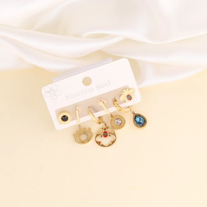 Detail of stainless steel earring set with moon, star, and bee motifs on a display card