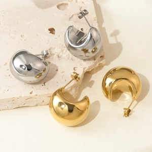Polished gold and silver stainless steel C-shaped drop earrings on stone background