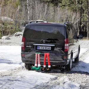 Elf and Santa legs sticking out of a car trunk for Christmas exterior decoration