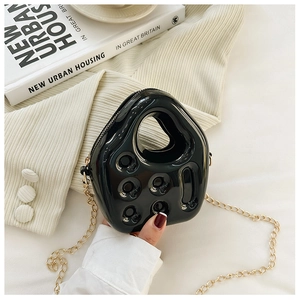 Detail of black jelly bag with unique hollow design and elegant gold chain strap