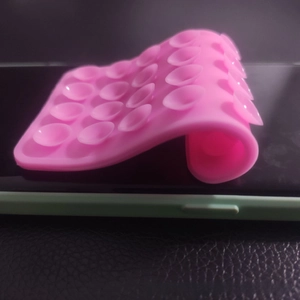 Detail view of flexible pink silicone suction cup pad showing high grip on mobile phone