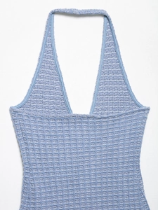 Detailed macro view of light blue waffle-knit fabric on a halter-neck dress texture