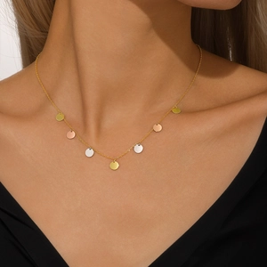 Detail of s925 silver necklace with sparkling gold, silver and rose gold discs