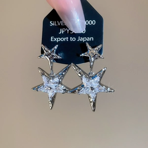 Detailed macro view of Silver 1000 earrings featuring sparkling double star zircon pendants