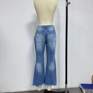 Détail arrière d'un jean large bleu avec ourlet effiloché et déchirures sur mannequin