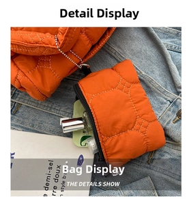 Detail of an orange quilted mini pouch with diamond stitching and silver bead chain