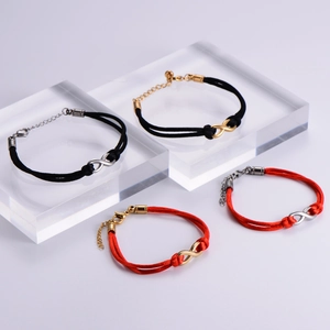 Close-up of infinity charm woven bracelets in red and black with metallic lobster clasps